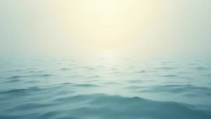 Sunrise over a calm ocean with a pale yellow sky and gentle waves. (serene seascape)